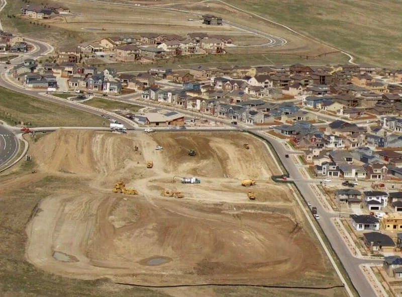 about-05 view of a large work site with many homes in the distance