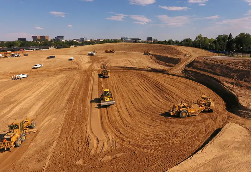about-06 cars and tractors in large dirt pit